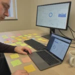 Wide desk with laptops and sticky notes